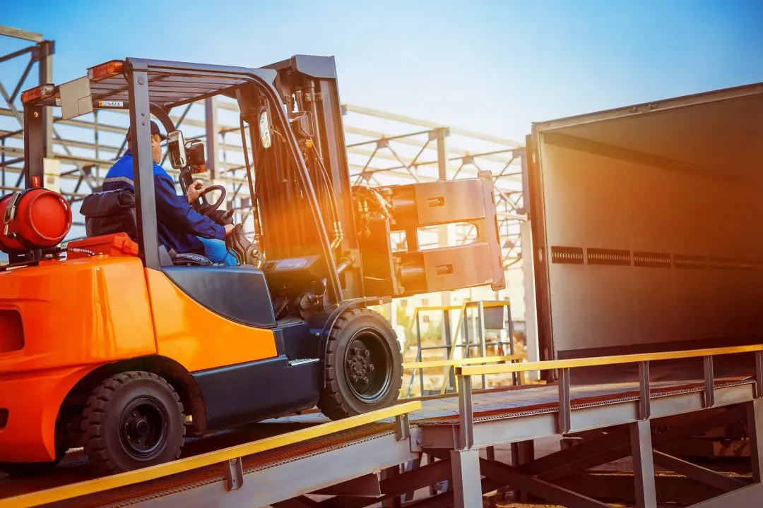 Forklift handling materials near a loading bay