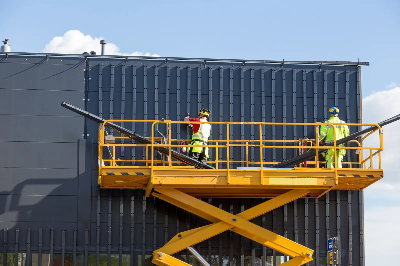 Mobile elevated work platform beside a building
